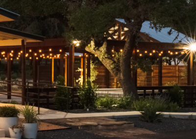 outdoor ranch venue with string lights, oak trees and concrete pathways - event venues in texas