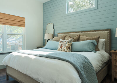 bedroom with large bed and light blue shiplap wood behind