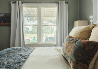 large bed with window on the wall behind it